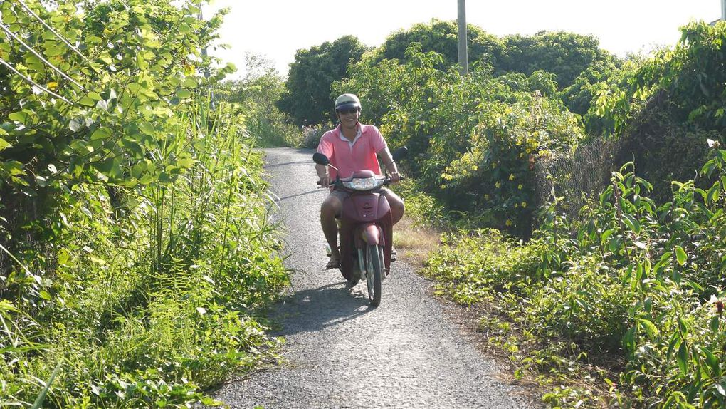 Sur la route de Cai Be (marché flottant des grossistes). Une belle étape fleurie avec des orchidées, des frangipaniers et l'arbre du voyageur...nous nous arrêtons dans un temple caodaiste. C'est une religion qui associe beaucoup d'autres.Nous allons ensuite voir le marché flottant de Cai Be avec ses gros bateaux chargés de fruits...Le midi nous nous arrêtons chez l'habitant, au bord du fleuve pour déguster le poisson éléphant.Nous logeons chez  un autre habitant en fin de journée. Le soir, nous avons participé à la préparation de nems fris (avec de la pâte de riz très légère comme de la dentelle). C'est une spécialité du Mékong. Ils sont aussi très habile pour sculpter les légumes (ici de la papaye) comme éléments de décoration. Les maisons sont en bois. Pas de climatisation mais des ventilateurs. Au matin suivant, nous sommes allés tous ensemble à vélo le long des arroyos en empruntant des petits sentiers étroits. 