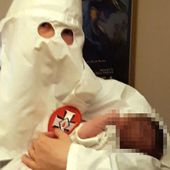 Adam, 22 ans et accusé d'être un terroriste néo-nazi, pose avec son nouveau-né, Adolf, alors qu'il porte le costume du Ku Klux Klan