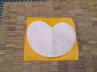 2 - Découper une forme en coeur dans du papier sulfurisé, reporter ce gabarit sur la tranche de mimolette et découper. Dans la 2ème tranche de poulet réaliser un disque avec un emporte-pièce rond qui servira pour la tête du chien. Faire les yeux du chien dans les chutes de la tranche de mimolette. Couper une olive noire dénoyautée en fine rondelle et en petits morceaux courbes pour les yeux, la bouche puis tailler de petits éclats noirs pour les moustaches. Une rondelle de cornichon et le bout sans trou de l'olive noire serviront à réaliser la truffe. Découper dans la tomate un morceau en forme de langue, 2 bandes rectangulaires dans la 2ème tranche de poulet pour les pattes et deux demi-cercles pour les oreilles.