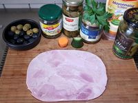 1 - Superposer 2 tranches de jambon et les tailler en rectangle (garder les chutes pour les utiliser dans une recette de rillettes ou de cake...). Placer le jambon sur un plat de service rectangulaire (ici une assiette imitation ardoise). Détailler dans la carotte 8 billes avec une cuillère parisienne et 2 petits tronçons. Evider les tronçons pour y positionner le concombre taillé en forme de feuilles comme sur les photos. Placer ensuite les divers éléments : nid de carotte et concombre, rondelles de cornichons, d'olives vertes et noires, câpres, fleurs de câpres, billes de carotte, feuilles de persil plat frais, 1ères fleurs du jardin comestibles, points de mayonnaise,  sur ou autour des tranches de jambon suivant votre inspiration. 