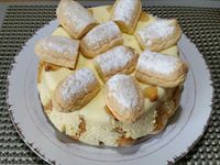 4 - Au moment de servir, démouler la charlotte, et décorer avec des moitiés de biscuits à la cuillère sur le dessus, des quartiers de mandarines et finir en parsemant de copeaux de pralinoise (ou chocolat au choix). Déguster aussitôt !