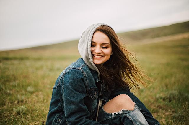 Une jeune femme souriante assis dans l’herbe