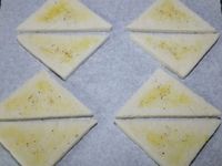 2 - Frotter les tranches de pain de mie avec l'ail. Les couper en diagonale pour obtenir des triangles, et les badigeonner au pinceau avec de l'huile d'olive (ou du beurre fondu).Disposer les tranches de pain de mie sur une plaque allant au four recouverte de papier sulfurisé, parsemer un peu de piment d'Espelette et passer au grill du four pendant quelques instants pour les dorer. Pendant ce temps battre les 4 oeufs en omelette, saler et poivrer légèrement.