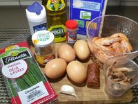 1 - Peler les crevettes roses et grises. Oter la peau du chorizo, le découper en petits morceaux. Laver et ciseler les brins de ciboulette. Peler l'ail.