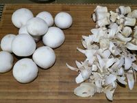 1 - Equeuter les champignons de Paris et peler les têtes. Les trancher en fines lamelles, réserver. Peler et hacher finement l'échalote. Prendre des petites piques en bois et embrocher les gambas de façon à ce qu'elles se maintiennent droites à la cuisson (ne pas ôter la carcasse avant d'embrocher les gambas).