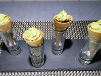 1 - Réaliser les cônes en feuilles de Brick comme expliqué sur la vidéo. Les garnir ensuite d'une mousse d'avocat à la crème fraîche assaisonnée de sel et de poivre, et des ingrédients de votre choix, ici : petits dés de tomate ou de betterave, crevettes grises, bâtonnets de jambon de Parme, le tout parsemé de quelques graines de sésame et de piment d'Espelette. Servir en amuse-bouche à l'apéritif !  