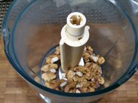 1 - Battre l'oeuf en omelette et réserver. Casser les noix et les passer au mixeur pour les réduire en poudre. Ecraser le beurre à la fourchette pour en obtenir une pommade. Incorporer le sucre, la poudre de noix, la moitié de l'oeuf battu et bien mélanger. Réserver cette préparation.