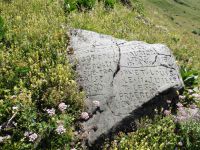 Une stèle gravée difficile à déchiffrer. Le Charbonnet en cascade. Des ruines (peut-être celles de Bognieu).