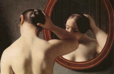 Une femme se coiffe devant le miroir