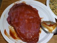 2 - Passer la viande de boeuf dans le ketchup des deux côtés, puis dans le pesto. Placer dans un plat allant au four. Arroser d'un filet d'huile d'olive et mettre au four th 7 (210°) 7mn très saignant, 10 mn saignant, 12 mn à point.  Laisser reposer quelques minutes avant de découper et servir avec un accompagnement de riz par exemple.