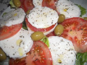 c'est une salade composée de rodelles de tomates et mozzarella sur un lit de laitue le tout assaisonner avec de l'huile d'olive, jus de citron et basilic