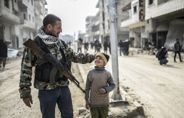 Un combattant kurde et son fils dans Kobané, libéré.  Crédit photo: AFP.