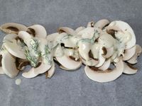 3 - Couper le 1/2 citron vert en fines rondelles. Recouvrir une plaque allant au four d'un grand rectangle de papier sulfurisé, disposer au centre les champignons émincés, puis arroser avec la préparation de sauce. Couper le pavé de saumon en 4 et placer les morceaux par dessus, poivrer, saler et saupoudrer de piment d'Espelette. Venir ajouter un peu d'aneth, et terminer par les rondelles de citron vert. Refermer les papillotes (voir technique de pliage dans l'article "Papillotes de gambas p-d-terre au beurre d'herbes") et enfourner à th 7 pour 15 à 18 mn. 