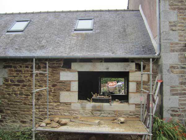 Piquage de l'enduit ciment intérieur, percement du mur et pose d'une fenêtre en pierres de taille avec arrières linteaux en chêne et tablette intérieure en granit