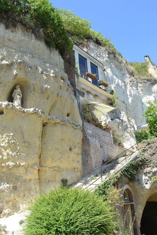 le village troglodyte de TROO -  et en plus il faisait vraiment TROP chaud !                             rôo est l'un des villages les plus jolis et insolites de France. Son site et son agencement très particuliers : des terrasses étagées, des grottes, des sentiers charmants, des escaliers partout. Pas vraiment de rues, pas de centre, c'est le mystère qui donne envie de partir à sa découverte. D'abord son nom : on en trouve la première mention au XIème siècle. L'interprétation la plus courante est trou, allusion aux cavernes qui creusent la colline. Trôo serait l'orthographe anglaise (trôo a été occupé par les Anglais du temps des Plantagenêts) ou angevine ancienne. De nombreux vestiges prouvent son ancienneté et son histoire très riche, les habitations troglodytiques donnent une idée de l'habitat ancien et le réseau souterrain de caves et galeries rappelle que des périodes mouventées de notre histoire ont amené les gens à s'y réfugier et à creuser de plus en plus loin.     