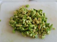 2 - Peler et tailler l'avocat en tranches puis en petits dés, les citronner de suite. Une fois cuites, débarrasser les coques de leurs coquilles et récupérer le jus de cuisson en le filtrant. En garder quelques unes avec leurs coquilles pour la décoration. Dans le bol, ajouter l'avocat, et successivement la moutarde, l'huile et le jus de cuisson. Bien mélanger et terminer en intégrant les coques à la préparation, assaisonner légèrement et mélanger le tout.