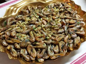 Peler une tête d'ail, dégermer et découper les gousses en petits morceaux. Les faire revenir 5mn dans une poêle avec de l'huile d'olive, Rajouter 1 kg de crevettes grises bien remuer, verser 5 cl environ de cognac et faire flamber.