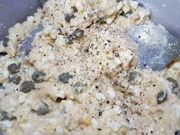 2 - Ecaler les oeufs, les couper, et les écraser à la fourchette, ajouter à la préparation au pain de mie. Incorporer les câpres, l'huile d'olive, mélanger et assaisonner avec du poivre.  Déposer les anchois sur du papier absorbant pour retirer l'excédent d'huile, et les couper en petits morceaux.