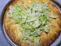 3 - Peler et écraser la gousse d'ail avec le plat d'un couteau. Faire revenir l'ail dans une poêle avec le beurre, rajouter le chou égoutté et laisser étuver à couvert, puis incorporer la moitié de la sauce à la crème, rectifier l'assaisonnement si besoin . Remettre le four à préchauffer th 6 (180°). Découper les pommes de terre en rondelles de 2 à 3 mm d'épaisseur, tailler la saucisse en rondelles de la même façon. Remettre le cercle autour de la pâte, étaler une couche de chou en tassant un peu, ôter le cercle et disposer les rondelles de saucisse, puis celles de pommes de terre au centre. Enfourner le tout pour 10 mn environ th 6 (180°). Déguster dès la sortie du four en rajoutant un peu de sauce au centre de la tarte fine pour un bel effet visuel.