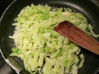 3 - Peler et écraser la gousse d'ail avec le plat d'un couteau. Faire revenir l'ail dans une poêle avec le beurre, rajouter le chou égoutté et laisser étuver à couvert, puis incorporer la moitié de la sauce à la crème, rectifier l'assaisonnement si besoin . Remettre le four à préchauffer th 6 (180°). Découper les pommes de terre en rondelles de 2 à 3 mm d'épaisseur, tailler la saucisse en rondelles de la même façon. Remettre le cercle autour de la pâte, étaler une couche de chou en tassant un peu, ôter le cercle et disposer les rondelles de saucisse, puis celles de pommes de terre au centre. Enfourner le tout pour 10 mn environ th 6 (180°). Déguster dès la sortie du four en rajoutant un peu de sauce au centre de la tarte fine pour un bel effet visuel.