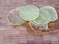 3 - Couper le 1/2 citron vert en fines rondelles. Recouvrir une plaque allant au four d'un grand rectangle de papier sulfurisé, disposer au centre les champignons émincés, puis arroser avec la préparation de sauce. Couper le pavé de saumon en 4 et placer les morceaux par dessus, poivrer, saler et saupoudrer de piment d'Espelette. Venir ajouter un peu d'aneth, et terminer par les rondelles de citron vert. Refermer les papillotes (voir technique de pliage dans l'article "Papillotes de gambas p-d-terre au beurre d'herbes") et enfourner à th 7 pour 15 à 18 mn. 