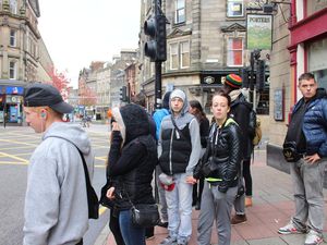 Promenade dans le vieux centre ville de Stirling : le drapeau écossais, une boutique de bonbons et une voiture verte.