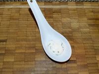 3 - Disposer un peu de crème dans le fond de cuillères ou mini-ramequins à apéritif, puis déposer délicatement les nids de brick, placer sur le nid une moitié d'oeuf de caille, ajouter un peu de fleur de sel, du paprika, quelques graines de sésame et décorer d'un brin de persil plat.