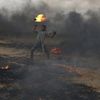 A Palestinian holds a fire during clashes with Israeli troops