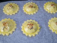 4 - Prélever à l'aide d'un emporte-pièces de 8 cm de diamètre 12 pièces de pâte en forme de fleur. Placer 6 fleurs sur une plaque allant au four recouverte de papier sulfurisé. Déposer au centre de ces 6 pièces un petit tas de farce en laissant 1 cm environ de bord. Avec un pinceau humecter à l'eau le bord de la pâte et venir recouvrir avec une 2ème fleur en pâte, bien souder délicatement les bords, puis à l'aide d'un verre d'un diamètre inférieur à votre fleur, marquer un cercle sur le dôme de chaque pièce (voir photo). Dorer au pinceau avec un jaune d'oeuf dilué dans un peu d'eau (ou de lait) Parsemer de graines de pavot et de sésame, saupoudrer de piment doux ou paprika .... Mettre à cuire au four th 6,5 (200°) pour 10 à 15 mn en surveillant. La pâte doit être bien gonflée et dorée.