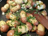 2 - Pendant la cuisson des pommes de terre au four, peler, dégermer l'ail, ciseler le persil et réserver. Sortir le plat du four et retirer l'excédent d'huile. Retransférer les pommes de terre dans la poêle, remettre sur le feu avec1 bonne cuil. à soupe de beurre (30 gr), ajouter l'ail, une partie du persil (en garder une petite partie pour la décoration finale), mélanger délicatement et rapidement pendant quelques instants et remettre au four pour 2 mn. Les ressortir, dresser sur un plat de service et répartir le persil haché restant. Déguster aussitôt.