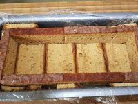 2 - Oter le trognon et couper en cubes. Mettre dans une casserole avec 1 cuil. à soupe de jus de poire et la cannelle en poudre, laisser sur feu très doux pendant 25 mn. Pendant ce temps tapisser un moule à cake de film étirable (pour faciliter le démoulage), puis positionner des tranches de pain d'épices dans le fond et contre les parois du moule (en retaillant au besoin). Veuiller à ce que les tranches soient bien jointes et caler éventuellement les bords avec des chutes de pain d'épices pour qu'ils soient bien droits.