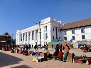 A côté du temple de Narayan Mohan, cet immense bâtiment blanc ci-dessus reste un souvenir amer pour les népalais puisque des colons anglais ont selon la mémoire ancestrale détruit un temple pour ériger ce parlement occidental néoclassique et anachronique, comme un affront aux croyances et convictions locales, un acte de domination d'une vulgarité sans nom, un pied salement posé sur le respect d'un peuple...et puis Mahendreswor Temple, dédicacé à Shiva et l'un des plus connu de la vallée, enfin la place Basantapur et ses échoppes aux souvenirs, quelques structures qui nous rappellent avec tristesse l'année 2015, et  des marchands qui rivalisent de couleurs avec leurs fleurs...