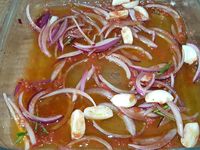 1 - Eplucher et couper l'oignon rouge en lamelles. Peler, dégermer l'ail et couper. Laver le thym et le romarin. Dans un plat en verre, mélanger les huiles, le vinaigre, ajouter l'oignon et l'ail émincés, la pulpe de tomate, les herbes (thym, romarin), le paprika doux, le piment d'Espelette et le sel. Déposer les tranches de poitrine de porc dans le plat, les retourner, couvrir d'un film étirable et réserver au réfrigérateur pour 3 h. Au bout des 3 h sortir du frigo, retourner les tranches sur l'autre face et mettre à nouveau au réfrigérateur pour 3 h.