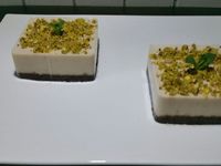 5 - Sortir les carrés du réfrigérateur, verser la préparation mixée citron/noix de cajou sur la base choco et replacer au réfrigérateur pour 1 h. Mixer les pistaches et quelques rondelles de kiwis déshydratées (10gr ) pour obtenir des brisures. Ressortir du réfrigérateur les gâteaux citron-choco, ôter délicatement les moules, parsemer de brisures de kiwi-pistache. Décorer d'une chips de kiwi et de points, de gel kiwi-menthe, d'une feuille de menthe et servir.
