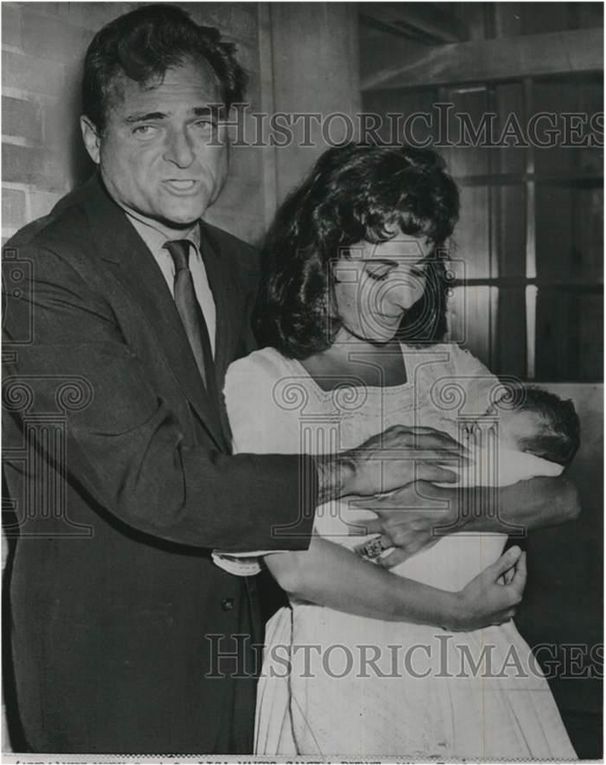 1957, September 3, AP wire release:  - New York - Liza makes camera debut - Mike Todd lends a helping hand as little Liza Todd leaves Harkness Pavilion hospital here today in the arms of her mother, actress Elizabeth Taylor. The parents came here from their Connecticut home to pick up Liza, born prematuraly August 6. (AP Wirephoto)