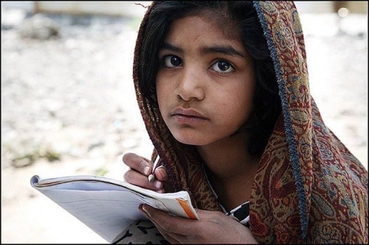 Une petite fille essaie d'étudier dans un champ au Pakistan. Srizki