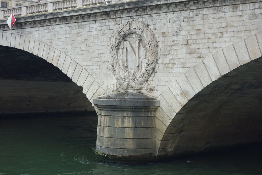 Le pont au Change, d'une longueur de 103 mètres, a été réalisé par les ingénieurs Vaudrey et Lagalisserie, en 1858, sous le règne de Napoléon III. Le « N » impérial de Napoléon III, sculpté par Cabat, est identique à celui du Pont Saint-Michel, lui aussi situé à Paris.