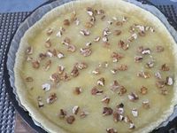 2 - Etaler la pâte dans un moule à tarte, piquer le fond à la fourchette. La recouvrir de papier sulfurisé dans lequel vous disposerez des légumes secs au choix (haricots secs, lentilles, pois chiches, cacahuètes natures .....). Enfourner pour 8 mn environ pour cuire la pâte à blanc. Pendant ce temps, couper quelques olives noires en rondelles. Casser l'oeuf entier dans une jatte, y ajouter la ricotta, bien mélanger à la spatule pour que la préparation soit homogène, saler et poivrer. Sortir du four la pâte précuite, retirer légumes secs et papier sulfurisé, répartir sur la pâte les noix concassées, le mélange fenouil-oignon-échalote-ail, parsemer de rondelles d'olives noires et de câpres, puis finir en répartissant sur le tout la préparation à la ricotta. Enfourner à nouveau pour 20 à 25 mn (th 6,5/7) en surveillant.