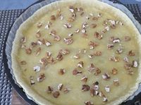 2 - Etaler la pâte dans un moule à tarte, piquer le fond à la fourchette. La recouvrir de papier sulfurisé dans lequel vous disposerez des légumes secs au choix (haricots secs, lentilles, pois chiches, cacahuètes natures .....). Enfourner pour 8 mn environ pour cuire la pâte à blanc. Pendant ce temps, couper quelques olives noires en rondelles. Casser l'oeuf entier dans une jatte, y ajouter la ricotta, bien mélanger à la spatule pour que la préparation soit homogène, saler et poivrer. Sortir du four la pâte précuite, retirer légumes secs et papier sulfurisé, répartir sur la pâte les noix concassées, le mélange fenouil-oignon-échalote-ail, parsemer de rondelles d'olives noires et de câpres, puis finir en répartissant sur le tout la préparation à la ricotta. Enfourner à nouveau pour 20 à 25 mn (th 6,5/7) en surveillant.