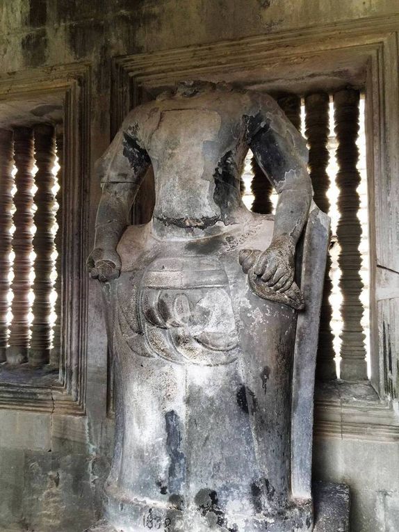 La construction d'Angkor Wat (qui signifie "la pagode de la ville" en khmer) a débuté au 12ème siècle et a duré 37ans. Ce temple est entièrement dédié à Vishnou, dieu suprême de l'hindouisme. Avant de passer les portes principales pour entrer dans l'enceinte d'Angkor Wat, nous traversons un pont entouré de douves larges de 190m. Ces dernières étaient très certainement infestées de crocodiles autrefois. Une fois l'entrée passée, nous nous retrouvons sur une chaussée de 350m de long. De part et d'autre se trouvent des petits pavillons que nous pouvons visiter. Après avoir dépassé les bassins entourant la chaussée, nous pénétrons enfin dans le temple. Il y a foule, ce n'est pas simple de prendre des photos sans personne devant mais avec un peu de patience on y arrive ! Pas facile non plus d'arpenter les longs couloirs sans se faire pousser dans tous les sens. En même temps notre ami Batman nous avait prévenu que vers 9h les tours organisés débarquaient des centaines de personnes sur le site. Nous avons l'avantage de ne pas être pressé par le temps malgré l'heure de rendez-vous fixé avec notre chauffeur. Après avoir découvert la galerie sud, nous arrivons dans le sanctuaire. Celui-ci peut être visité mais, sécurité oblige, il faut faire la queue pour attendre de pouvoir y monter et ainsi éviter les accidents (qui pourraient avoir lieu si trop de personnes y montaient simultanément). Bon, je vous avoue que lorsque nous avons vu plus de cent personnes dans la file d'attente, on a abandonné l'idée ... On est donc redescendu découvrir la galerie Est et sa fresque murale. Angkor Wat est sublime et on n'a aucun mal à imaginé la cité grandiose qu'était ce site autrefois. Je pourrais rester des heures à découvrir ce temple en me perdant dans mon imagination mais l'heure qui file me fait revenir à la réalité. Nous retraversons donc toute l'enceinte pour retrouver notre ami Batman.