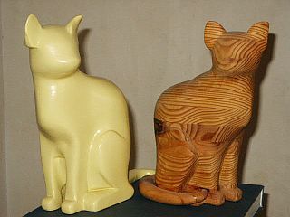 Le chat jaune. Bois pin des Landes, hauteur 21cm. Initialement ce chat était en bois brut. Une chute lors d'une séance de dépoussiérage lui a coûté la queue et une oreille. J'ai retravaillé l'oreille, mais pas la queue qu'elle a préféré réparer mochement avec de la pâte à bois. Il a été peint pour masquer cette infâmie. La base de ce premier chat est lestée de plomb. C'est un chat peint même chi ch'est pas Noël.