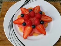 2 - Disposez sur une belle assiette à dessert, une fleur de pastèque, puis les petits disques de melon comme indiqué sur la photo. Recouvrez d'une deuxième fleur de pastèque. Placez les lamelles de fraises en étoile. Décorez le centre de framboises et myrtilles. Placez au réfrigérateur. Au moment de servir, posez une petite meringue sur votre dessert de fruits frais. Emiettez-en une autre sur la fleur étoilée, et parsemez de menthe ciselée et de zestes de combava. 