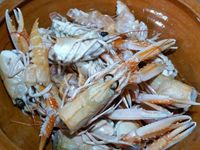 2 - Garder les têtes et les pattes des langoustines pour réaliser une bisque. Peler les échalotes et les gousses d'ail et les dégermer. Dans une casserole faire revenir dans un filet d'huile d'olive les carcasses de langoustines. Bien les écraser avec une spatule en bois pour faire ressortir le jus et permettre aux arômes de se libérer, laisser cuire 10 mn en remuant. Ajouter ensuite les échalotes, l'ail, le bouquet garni, laisser cuire 3 mn jusqu'à coloration. Incorporer ensuite la purée de tomates, et le concentré de tomates, mélanger et laisser fondre 2 mn. Couvrir enfin d'eau à hauteur, et laisser mijoter pendant 30 à 40 mn à feu doux.