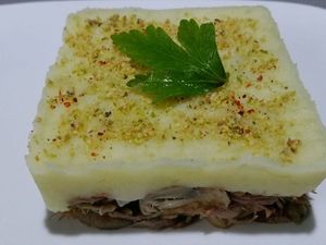 3 - Placer des emporte-pièces sur des assiette de service chaudes. Déposer une bonne couche d'effiloché de canard , bien tasser. Rajouter une couche de purée, égaliser et tasser à nouveau. Retirer délicatement les emporte-pièces. Avant de décorer vous assurer de la bonne température de vos plats, dans le cas contraire les repasser rapidement au four ou au micro onde. Saupoudrer les parmentiers de chapelure (noix de cajou et pistaches finement mixées), d'un peu de piment d'Espelette, et d'un brin de persil.