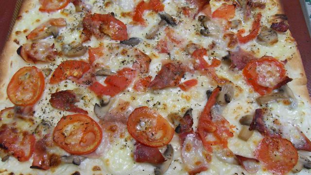 Pizza au jambon, champignons et tomates