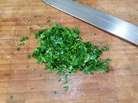 2 - Préparer la sauce. Peler et dégermer l'ail, le passer au presse-ail ainsi que le gingembre frais épluché. Râper tout le zeste d'un citron vert, et en presser le jus d'une moitié. Ciseler le persil plat et la ciboulette (si fraîche)