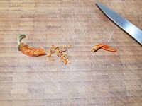 1 - Zester le citron. Le presser pour récupérer le jus. Concasser grossièrement les noix de cajou. Tailler le piment, peler et émincer l'échalote. Diluer dans 25 cl d'eau chaude le bouillon de volaille. Réserver.