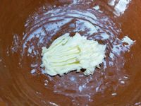 1 - Battre l'oeuf en omelette et réserver. Casser les noix et les passer au mixeur pour les réduire en poudre. Ecraser le beurre à la fourchette pour en obtenir une pommade. Incorporer le sucre, la poudre de noix, la moitié de l'oeuf battu et bien mélanger. Réserver cette préparation.