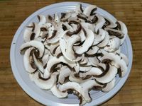 1 - Equeuter les champignons de Paris et peler les têtes. Les trancher en fines lamelles, réserver. Peler et hacher finement l'échalote. Prendre des petites piques en bois et embrocher les gambas de façon à ce qu'elles se maintiennent droites à la cuisson (ne pas ôter la carcasse avant d'embrocher les gambas).