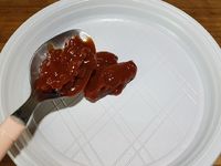 1 - Préchauffer le four th 7 (210°). Peler la carotte, la couper en rondelles. Tailler la branche de céleri en petits morceaux. Peler et hacher l'oignon nouveau, le gingembre. Peler et dégermer l'ail et le hacher également. Mettre dans un mixeur tous ces ingrédients taillés avec le sésame, les noix de cajou et la coriandre fraîche et mixer le tout grossièrement, assaisonner avec sel et poivre suivant vos goûts. Etaler ce pesto dans une assiette, et le ketchup dans une autre assiette.